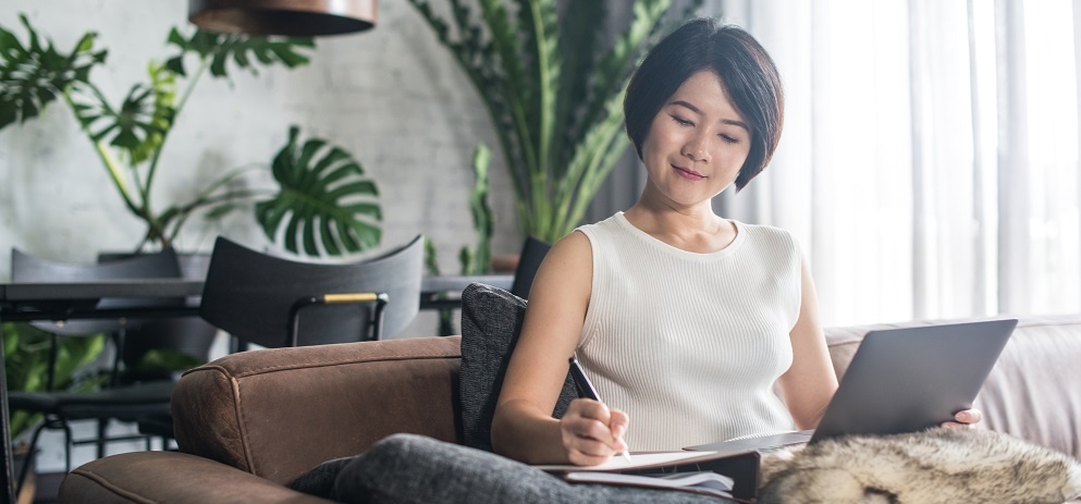 Happy Asian Woman Using The Computer At Home.