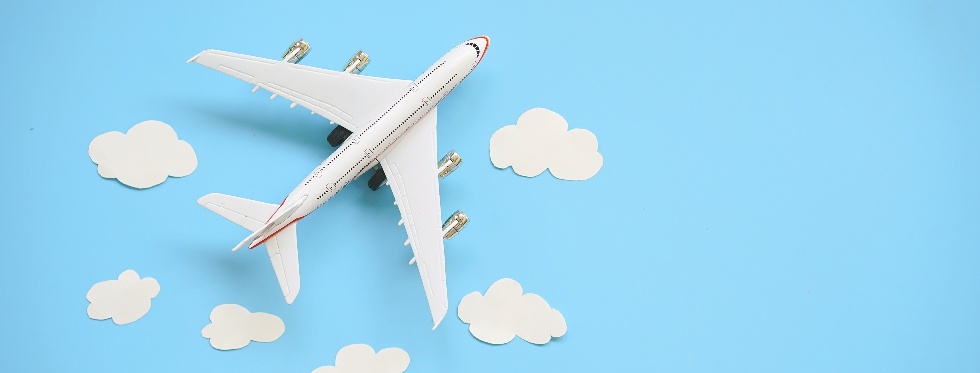 Flat Lay Design Of Travel Concept With Plane And Cloud On Blue Background With Copy Space.