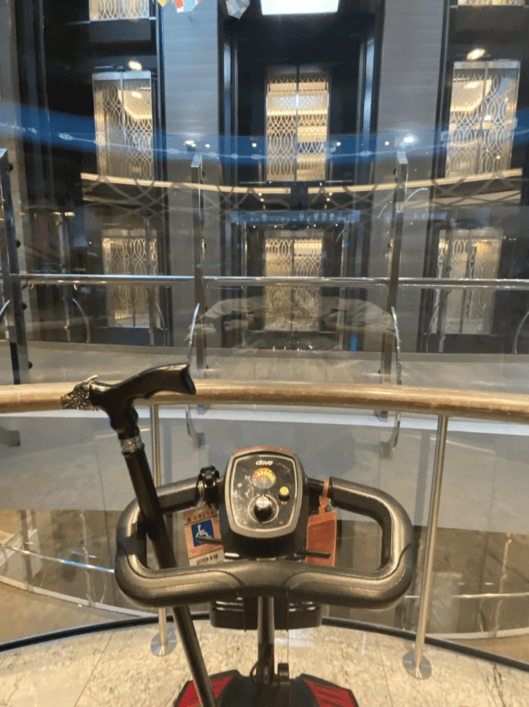 Mobility scooter on cruise ship facing interior glass wall 